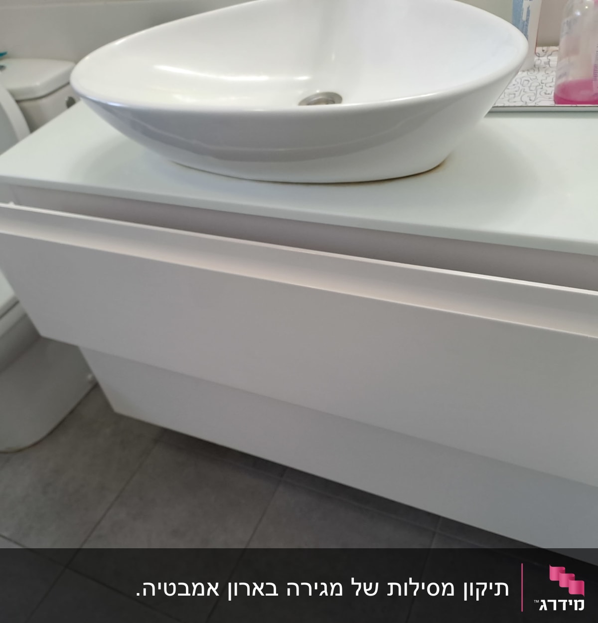 ארון אמבטיה עם מגירה פתוחה וכיור עליון